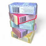 Pile de savons artisanaux naturels faits main en Occitanie avec emballages colorés – assortiment de la Savonnerie de Saint-Privat