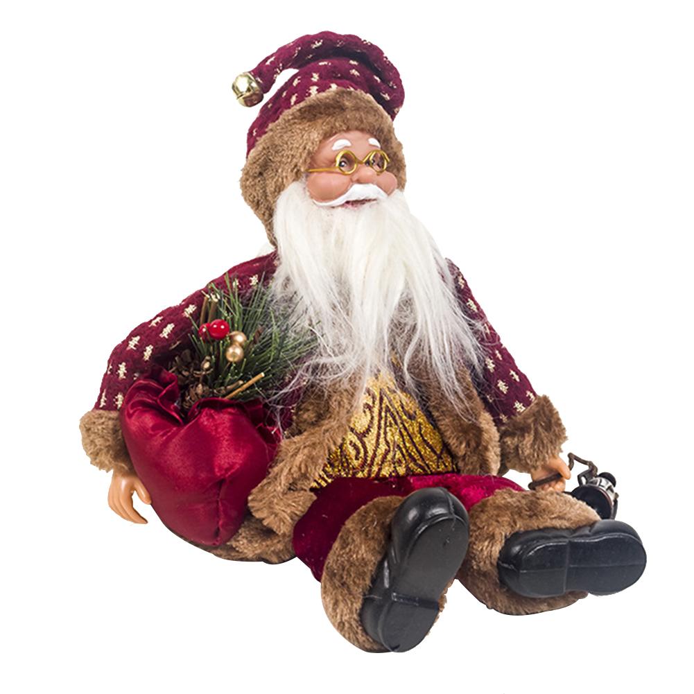 Un mignon petit garçon dans un costume de Père Noël est assis avec des jouets d'arbre de Noël