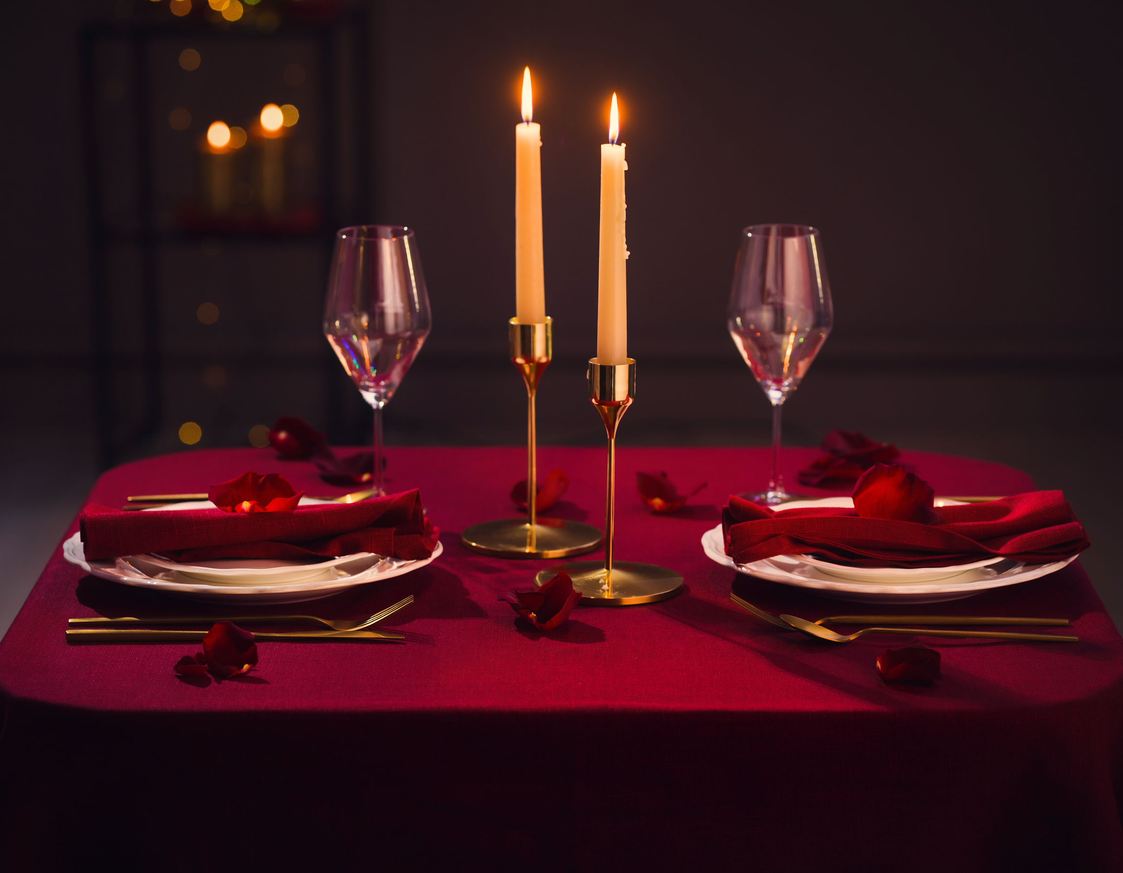 table saint valentin romantique avec bougies rouges et pétales de rose